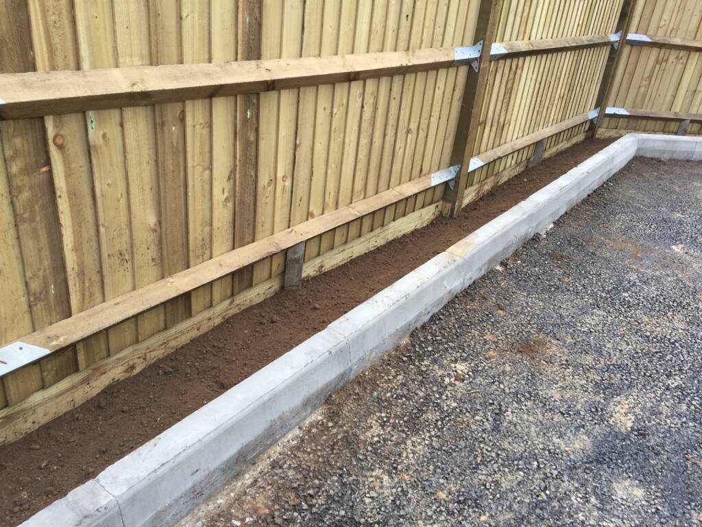 5 Reasons to Upgrade Your Fencing in 2026 2 Wooden fence next to a driveway