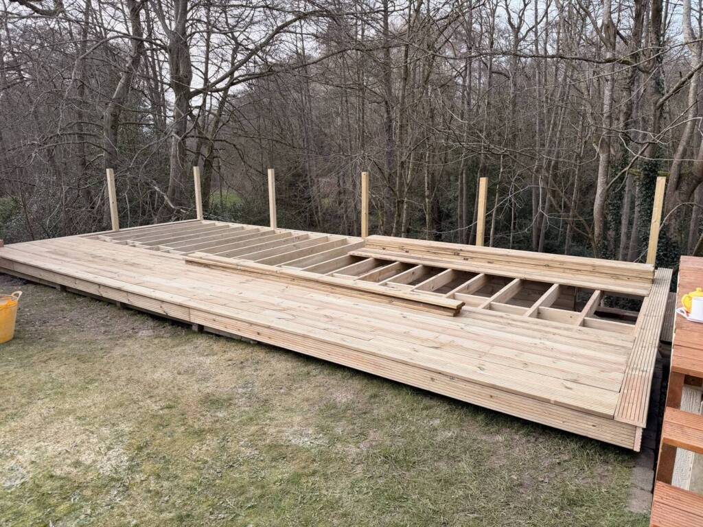 Composite vs. Timber Decking: Which is Best for Your Surrey Garden? 4 Timber decking in the process of being installed in a garden